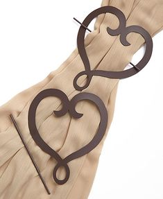 a pair of heart shaped scissors sitting on top of a piece of cloth