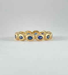 *THIS PIECE IS SOLD BUT CAN BE RE-MADE AS CUSTOM IF ORDERED BY 12/04/24* 18k yellow gold. Royal blue custom cut oval cut sapphires 3mm x 2mm. These gorgeous sapphires are set in an eternity band of super chunky oval bezels. The faces of the bezels have been brush finished by hand to give the gold a soft glow. - 18k yellow gold - blue sapphire - 1.44ctw sapphires - size 6.5 custom sizes available Available in 18k white, 18k yellow and 18k rose gold inquire for platinum pricing. Most CM pieces can Sapphire Jewelry Outfit, Blue Gold Ring, Royal Blue Accessories, Sapphire And Diamond Band, Rubin Ring, Sapphire Eternity Ring, Sapphire Band, Royal Blue And Gold, Blue Accessories