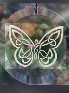 a glass ornament with a white butterfly on it's back and the words,