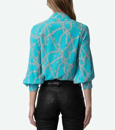 TUILE CDC CHAINS | WWSH00575 Women’s Aqua blue silk blouse Chain and ZV signature motifs Open V-neck and removable necktie Long sleeves and buttoned cuffs Round hem and side cut-outs 100% SILK Hand-wash or machine-wash inside out in a mesh laundry bag on a 20°C delicate cycle with a maximum spin speed of 400 rpm Air dry flat Iron inside out at a maximum of 110°C Model is 175 cm / 5' 8" and is wearing a size S This item is true to size. We recommend buying your usual size. A bold background with classic pattern makes a clean statement on this versatile silk blouse from Zadig & Voltaire. Framed by gathered-shoulder puff sleeves, this blouse features a hidden-button placket and elbow-length sleeves with button cuffs. Crafted from 100% silk, it offers a luxurious feel and a sophisticated look, Bold Background, Blue Silk Blouse, Jumpsuit Skirt, Shopping Event, Back Jewelry, Blue Silk, Classic Pattern, Elbow Length Sleeve, Flat Iron