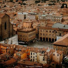 an aerial view of a city with tall buildings and lots of orange colored rooftops