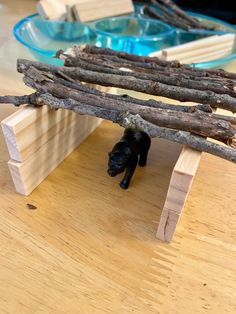 a black dog hiding under a piece of wood