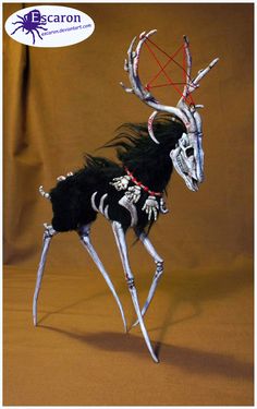 a black and white animal with horns on it's head is standing in front of a brown background