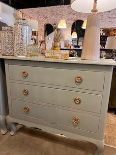 an antique dresser with gold handles and knobs in a room filled with other items