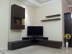 a flat screen tv sitting on top of a wooden entertainment center in a living room