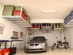 a car is parked in the garage with two shelves above it that hold various items