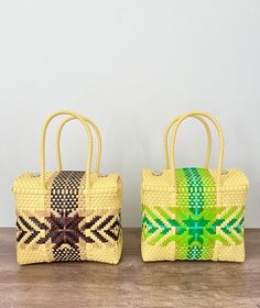 two woven bags sitting on top of a wooden table