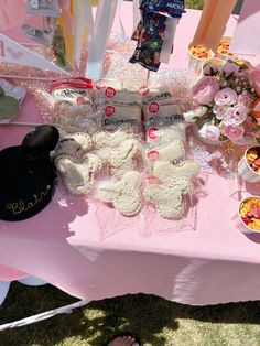 a pink table topped with lots of desserts and candies on top of it