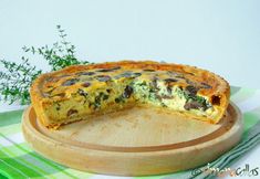 a quiche on a cutting board with one slice cut out and ready to be eaten