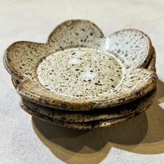 three brown and white dishes stacked on top of each other in the shape of hearts