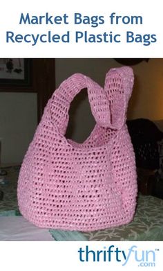 a pink crocheted bag sitting on top of a bed next to a lamp