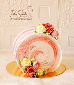 a cake decorated with flowers and icing on a plate in front of a wall