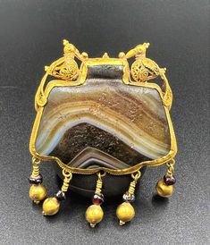 The Beautiful Gold Pendant With Beautiful Hand Work .The Pendant Was Beautifully Decorated With Birds Figures Along With Garnet Gems Stones Probably Ancient Seljuk Dynasty Era Art. Big Banded Agate Bead Was Wrapped Folded With These Gold Beautiful Hand Work. Good Conditions As Shown In The Pictures. NOTE The Agate Was Re Fixed Again To Tight With Gold. Because The Agate Was Loose. Size Weight Details Pictures Are Listed Above. We Provide Fast And Free Shipping Service World Wide To Our Customers Traditional Agate Jewelry For Collectors, Beautiful Gold Pendants, Persian Jewelry, Egypt Jewelry, Bird Figure, Garnet Gem, Details Pictures, Banded Agate, Hand Work