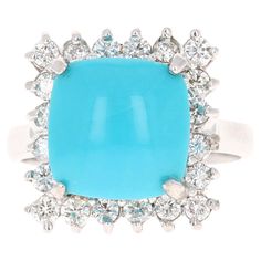 The Cushion Cut Turquoise is 5.00 Carats and is surrounded by a Halo of beautifully set diamonds. There are 20 Round Cut Diamonds that weigh 0.71 Carats (Clarity: SI2, Color: F). The total carat weight of the ring is 5.71 Carats. The ring is crafted in 14 Karat White Gold and weighs approximately 5.5 grams Ring size = 7 (Free ring sizing upon request) Gold Cocktail Ring, Gold Cocktail, Black Pendant Light, Cocktail Ring, Round Cut Diamond, Cushion Cut, Cocktail Rings, Round Cut, Diamond Jewelry