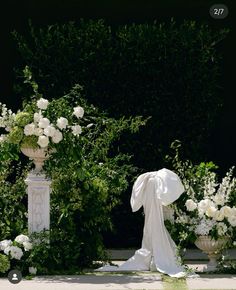 an outdoor ceremony with white flowers and greenery