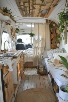 the interior of an rv with wood flooring and plants on the windowsills