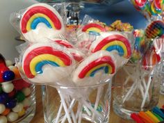 lollipops are sitting in a glass vase on a table with other candies