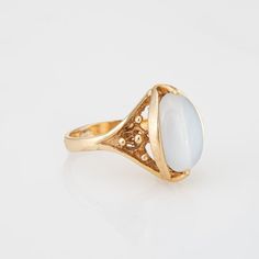 Stylish vintage moonstone cocktail ring (circa 1960s to 1970s) crafted in 10 karat yellow gold.    Cabochon moonstone measures 13.5mm x 9mm. The moonstone is in very good condition and free of cracks or chips.    The luminous moonstone glows with every movement of the hand, securely set in a bezel style mounting. The cocktail ring makes a nice statement on the hand. The medium rise ring (9mm - 0.35 inches) sits comfortably on the finger.    The ring is in very good condition and was lightly cleaned and polished.    Particulars:    Weight: 6.2 grams    Stones: Cabochon moonstone measures 13.5mm x 9mm. The moonstone is in very good condition and free of cracks or chips.    Size & Measurements: The ring is a size 5 3/4 (sizable). The mount measures 17mm in length (0.66 inches) and 11mm wide ( Classic Moonstone Ring For Formal Occasions, Classic Gold Moonstone Ring, Vintage 14k Gold Moonstone Ring, Classic Gold Moonstone Ring With Oval Cabochon, Formal 14k Gold Oval Cabochon Moonstone Ring, Formal White Moonstone Ring In 14k Gold, Vintage 14k Yellow Gold Moonstone Ring, Vintage Oval Moonstone Ring, Antique Oval Moonstone Ring