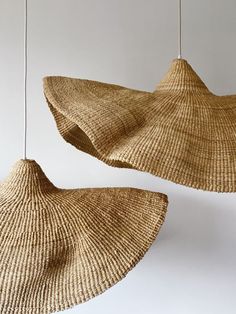 two large woven hats hanging from strings