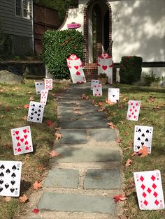 playing cards are on the ground in front of a house with red and black hearts