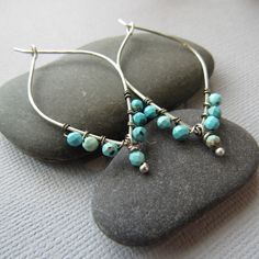 Each pair is handcrafted with sterling silver and features beautiful turquoise stones, measuring 2 inches long. Add a pop of color to your look with these unique and eye-catching earrings. Turquoise Teardrop Hoop Earrings Nickel Free, Artisan Turquoise Sterling Silver Earrings, Turquoise Hoop Earrings With Natural Stones As Gift, Turquoise Sterling Silver Hoop Earrings, Handmade Turquoise Hoop Earrings, Turquoise Natural Stone Hoop Earrings As Gift, Turquoise Sterling Silver Hoop Earrings For Pierced Ears, Sterling Silver Turquoise Hoop Earrings, Turquoise Teardrop Sterling Silver Hoop Earrings