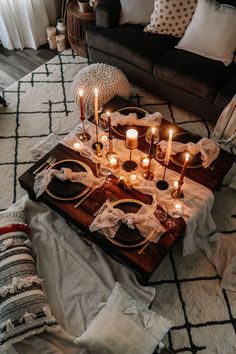 candles are lit on a tray in the middle of a living room with white and black decor