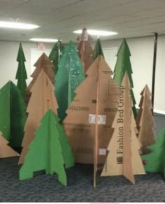 there are many trees made out of cardboard in an office building with carpeting on the floor