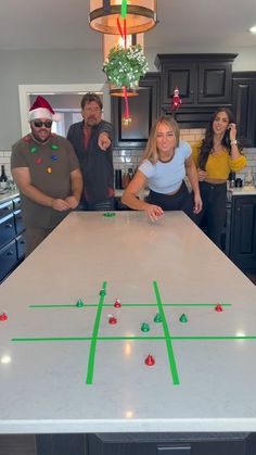 a group of people standing around a table with a soccer game on top of it