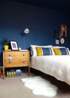 a bedroom with blue walls and white bedding