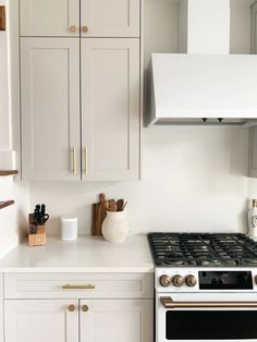 a white kitchen with an oven, stove and cupboards in the backround