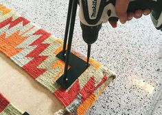 a person using a drill to fix a rug