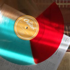 a red and blue record sitting on top of a wooden table