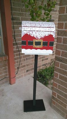 a mailbox with a santa clause painted on it is in front of a brick building