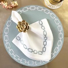 a plate with a napkin on top of it and a gold flower in the middle