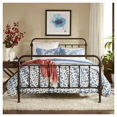 a metal bed frame with blue and white bedspread