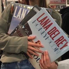 a woman holding several books in her hands