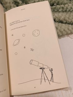 an open book with a drawing of a telescope on the cover and stars in the sky