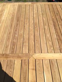 the shadow of a person standing on a wooden deck