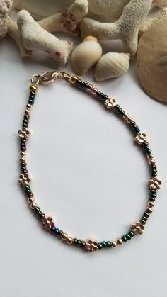 These green iris metallic beads really reflect a lot of different colours that was hard to capture in a picture. They colours are accented with some pretty round and flower shaped gold metal spacer beads. Approx 9" with lobster clasp. If you need additional length an extender chain can be added for no additional cost. Just add in Notes To Seller or convo me. Your anklet will last longer if you don't get it wet. ஐ ¸.**'¯) ஐ ¸.**'¯) ஐ ♥ All items handmade in beautiful Nova Scotia, Canada ♥ ** To c Summer Gold Beaded Bracelets With Flower Shape, Summer Gold Flower Beaded Bracelets, Summer Flower-shaped Gold Beaded Bracelets, Nova Scotia Canada, Anklet Jewelry, Nova Scotia, Handmade Design, Beach Summer, Different Colours