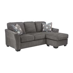 a gray sectional couch with pillows on it's back and one arm facing the sofa