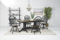 a dinning room table with chairs and a potted plant on the side wall