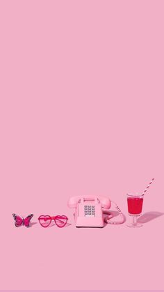 a pink phone and sunglasses on a pink background