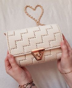 a person holding a white purse with a heart on it