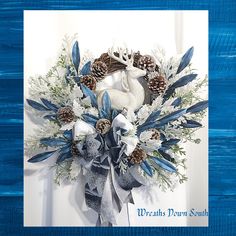 a blue and white christmas wreath with pine cones, snowflakes and an antelope