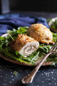 a close up of a plate of food with meatballs and greens on it next to a fork