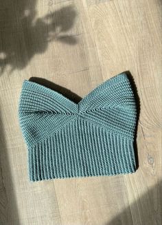 a blue knitted bow tie laying on top of a wooden floor