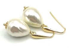 A pair of elegant earrings crafted with 24 K Gold Vermeil Made in Italy and simulated baroque white pearls. Would make a great gift for June birthdays or for bridesmaids. LENGTH:  1.7 inches - 4,4 cm  - 7 gr.  Pearl:   21 x 16 mm MATERIALS: 24 K Gold Vermeil - Made in Italy Simulated Pearls DELIVERY: All jewellery is shipped in a working day with registered mail. If you require quick delivery, please consider our Express Shipping option. Free pouch drawstring bag with every order BACK to SOFIA'S BIJOUX for more bespoke handmade jewellery. Gemstone Jewellery, bridesmaids gifts and birthstones: http://www.etsy.com/it/shop/Sofiasbijoux More Pearl Jewellery: https://www.etsy.com/uk/shop/Sofiasbijoux?section_id=28456147 More Earrings: https://www.etsy.com/uk/shop/Sofiasbijoux?ref=simple-shop-he White Pear-shaped Party Jewelry, White Pear-shaped Bridal Earrings For Party, Pear-shaped White Bridal Earrings For Party, Handmade Elegant Teardrop Earrings For Anniversary, Elegant Handmade Teardrop Earrings For Anniversary, Handmade White Pearl Earrings For Formal Occasions, White Handmade Pearl Earrings For Formal Occasions, Classic Handmade Earrings For Party, Handmade Pearl White Earrings For Formal Occasions