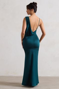 the back of a woman in a long green dress, with her hands on her hips