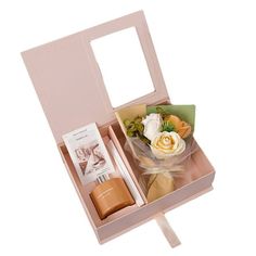 an open pink box with flowers and other items