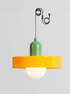 a green and yellow light hanging from a ceiling fixture with a cord attached to it